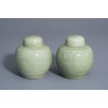 A pair of Chinese celadon jars and covers with underglaze dragon design, 19th/20th C.