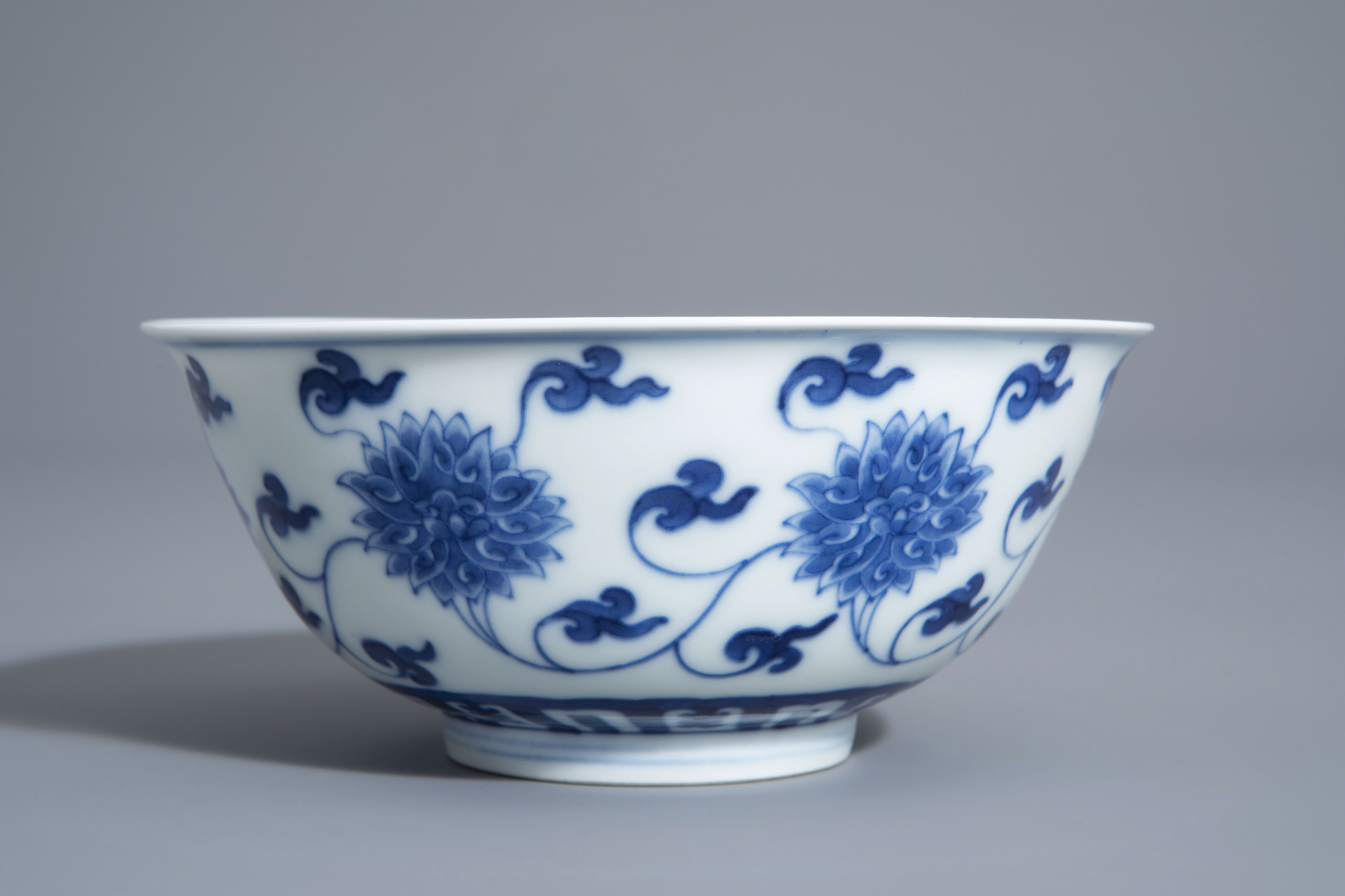 A Chinese blue and white 'lotus scroll' bowl, Kangxi mark, 19th/20th C. - Image 3 of 8