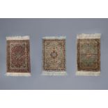 Three Oriental rugs with floral design and a central medallion, silk on cotton, 20th C.