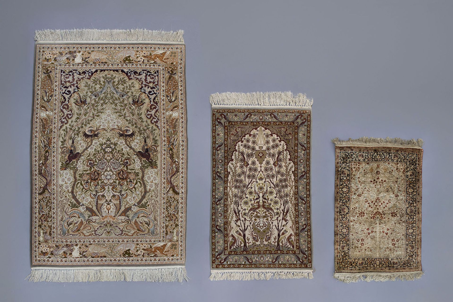 Three Oriental rugs with floral design and animals, wool and silk on cotton, Isfahan, 20th C.