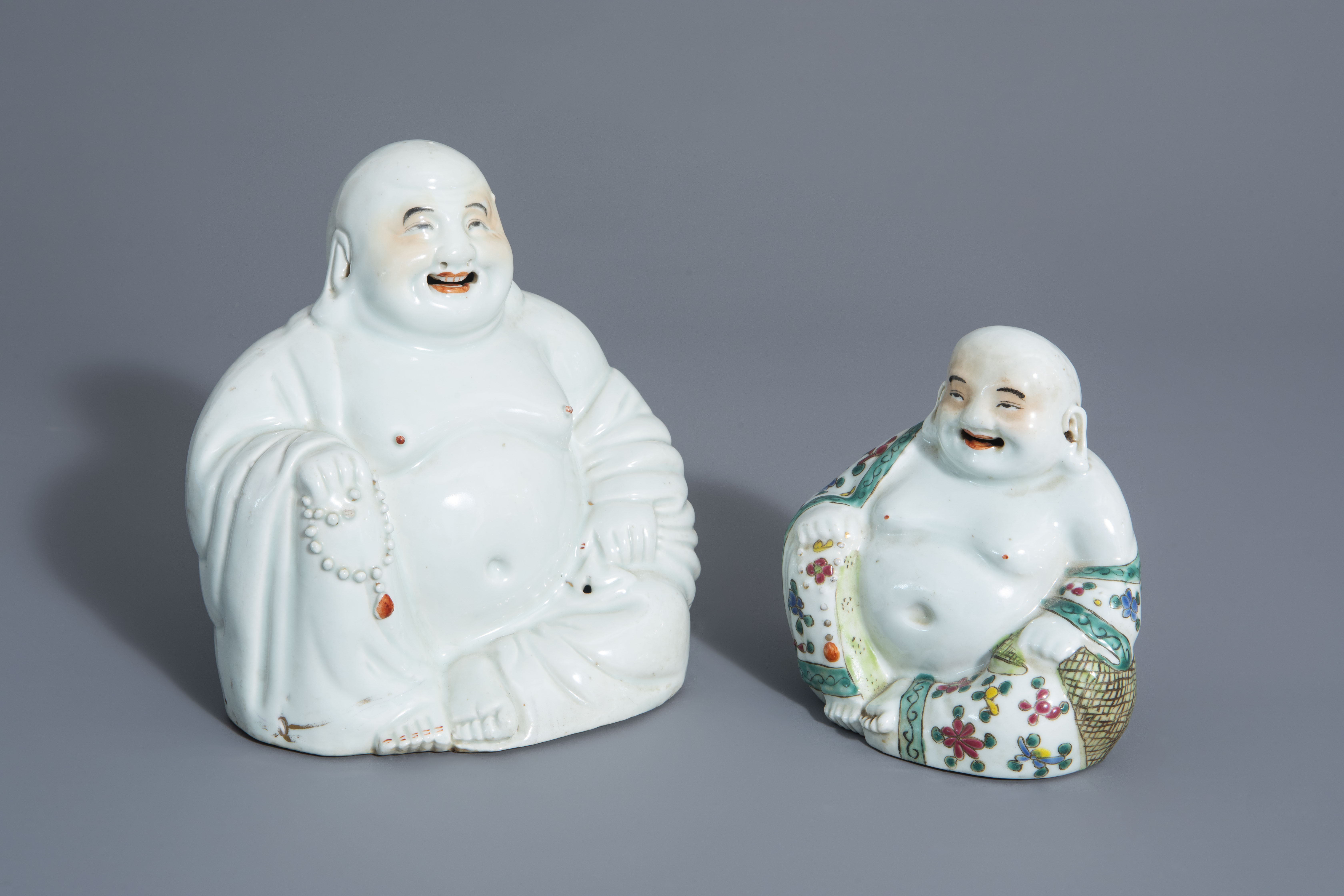 Two Chinese white, iron red, gilt and famille rose porcelain figures of Buddha, 19th/20th C.