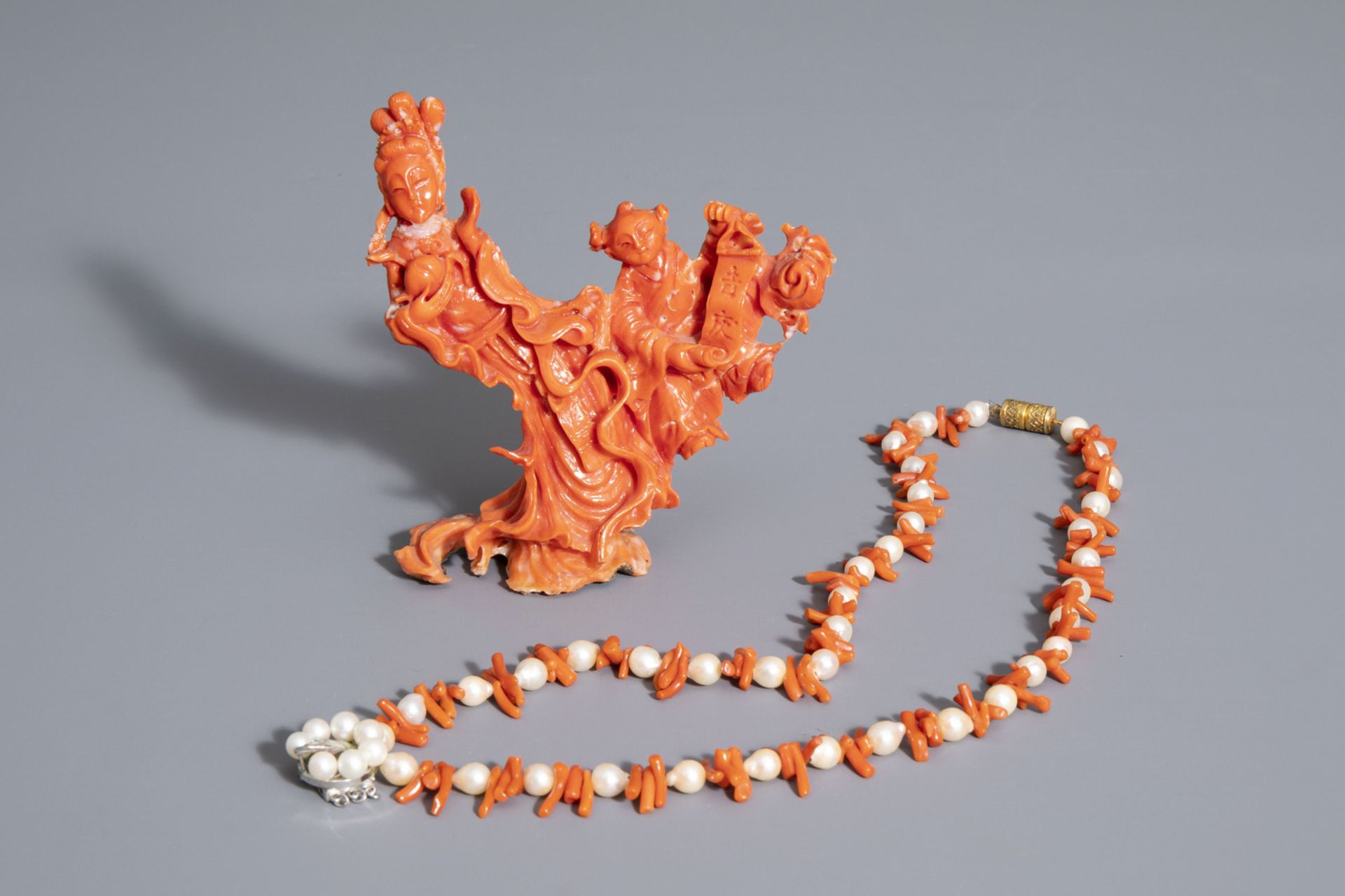 A Chinese carved red coral group of a lady with a child and a necklace with pearls, 19th/20th C.