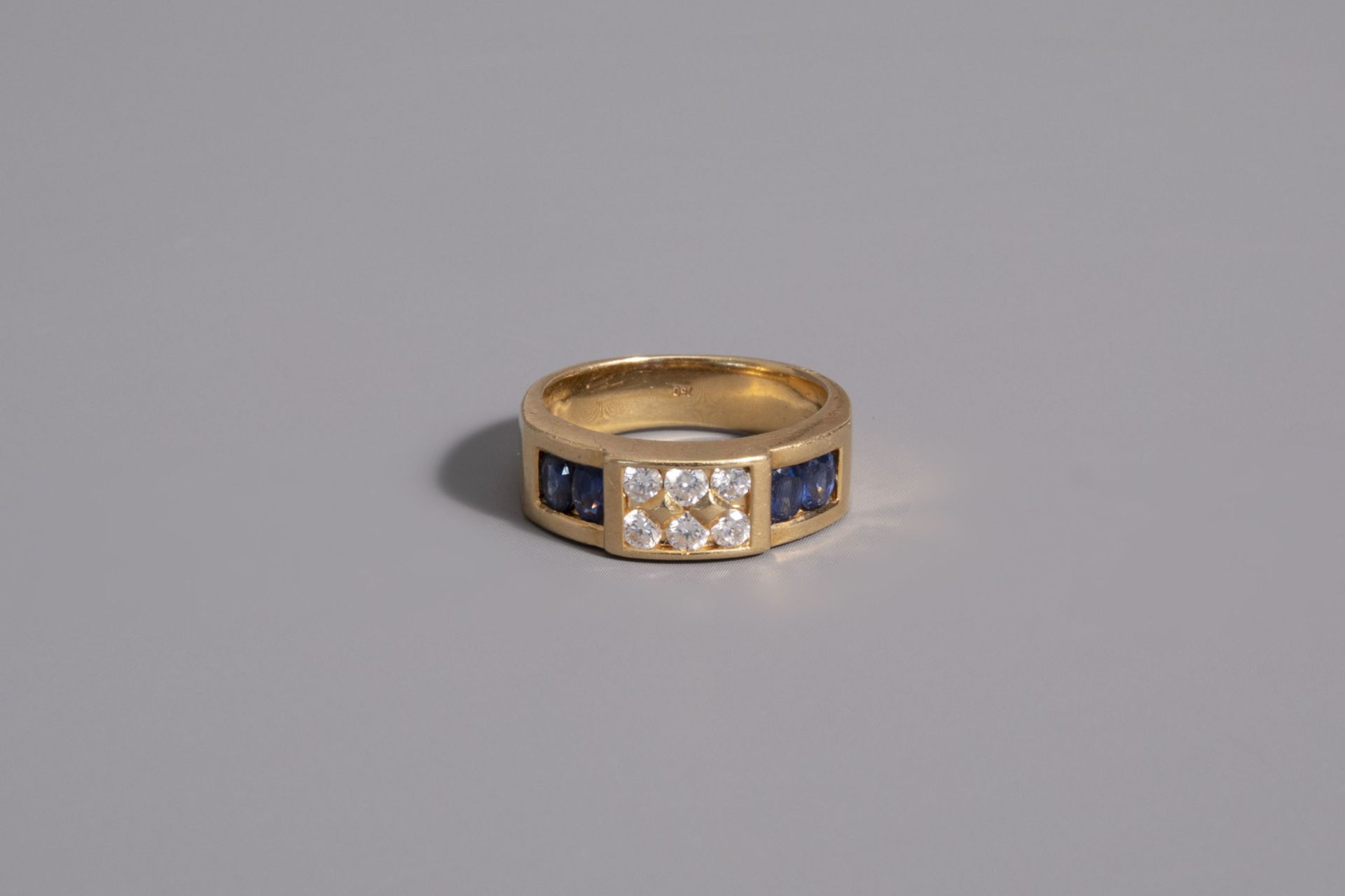 An 18 carat yellow gold ring set with four blue sapphires and six diamonds, 20th C.