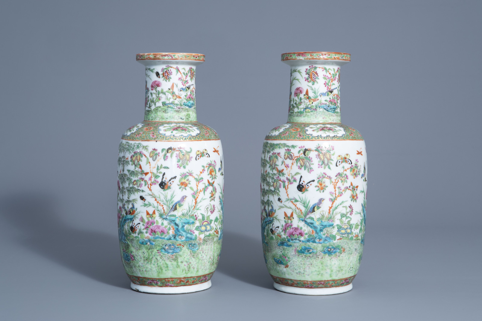 A pair of Chinese Canton famille rose vases with birds and butterflies among blossoms, 19thC.