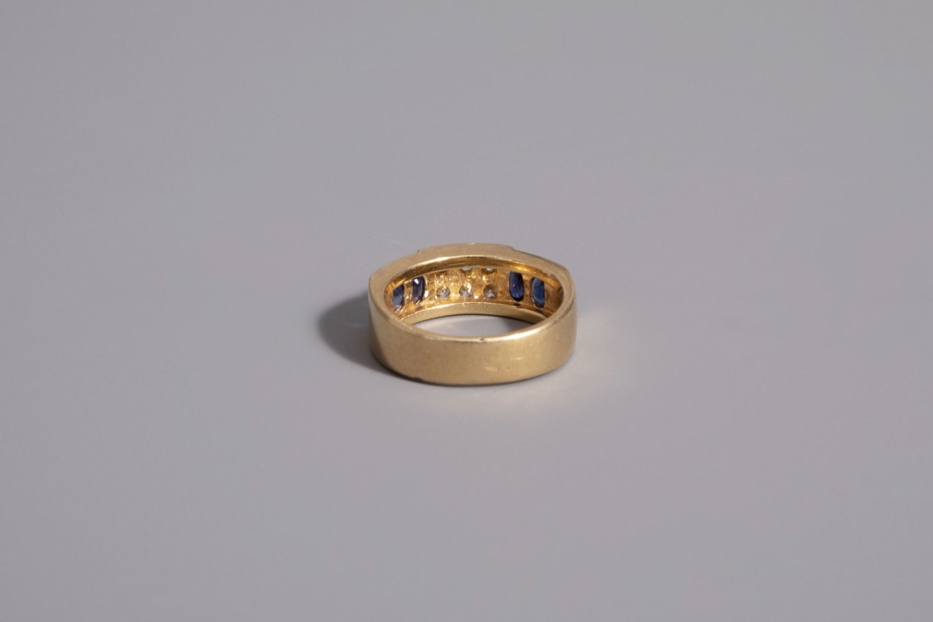 An 18 carat yellow gold ring set with four blue sapphires and six diamonds, 20th C. - Image 2 of 2