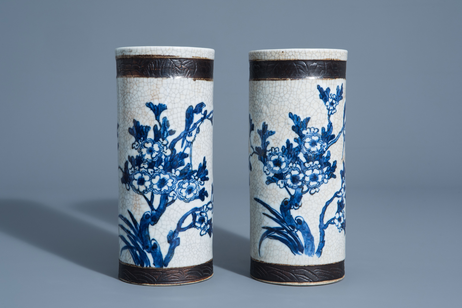 A pair of Chinese blue and white Nanking crackle glazed hat stands with floral design, 19th C.