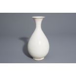 A Chinese monochrome cream glazed bottle vase, Song or later
