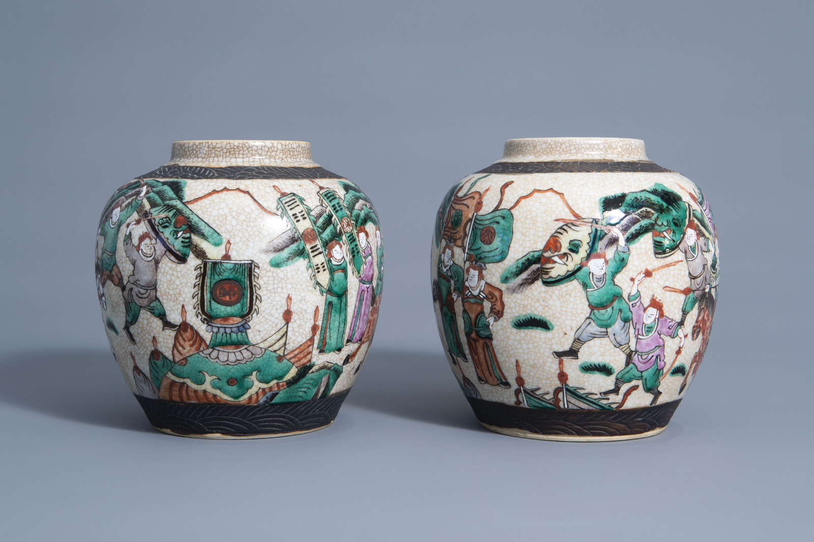 A pair of Chinese Nanking crackle glazed famille rose jars and covers with warrior scenes, 19th C. - Image 3 of 7