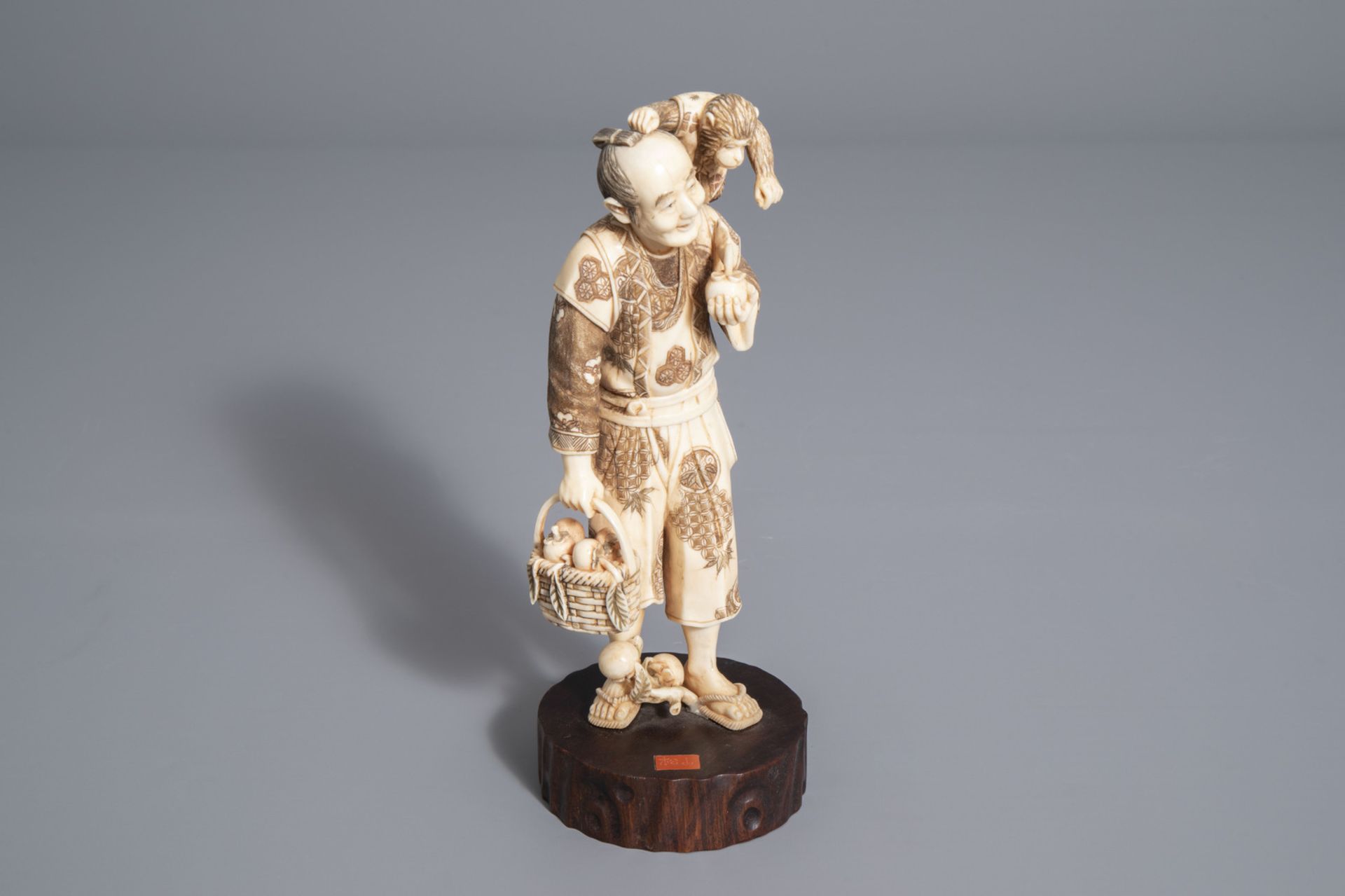 A Japanese ivory okimono of a fruit seller and his monkey, signed, Meiji, 19th/20th C.