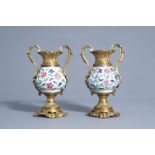 A pair of Chinese gilt bronze mounted famille rose vases with floral relief design, Yongzheng and 19