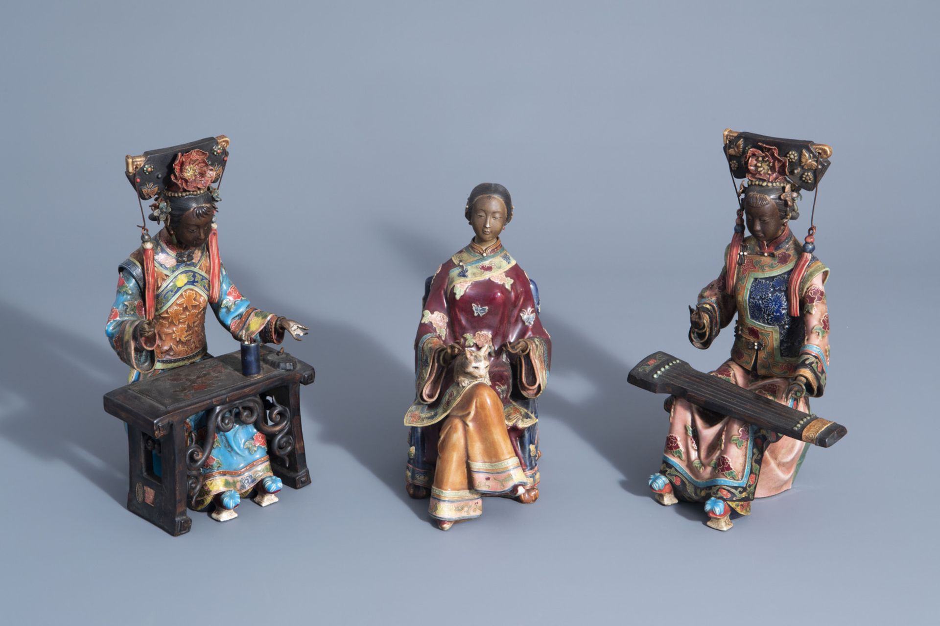 Three Chinese Shiwan pottery models of relaxing ladies, seal marks, 20th C.