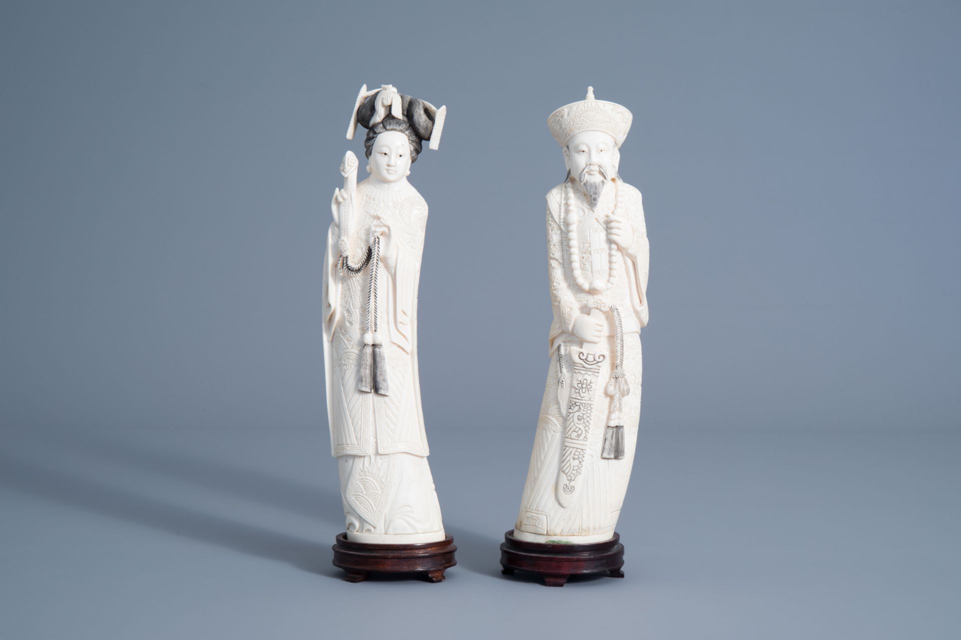A pair of Chinese carved figures of the emperor couple on wooden stands, about 1920