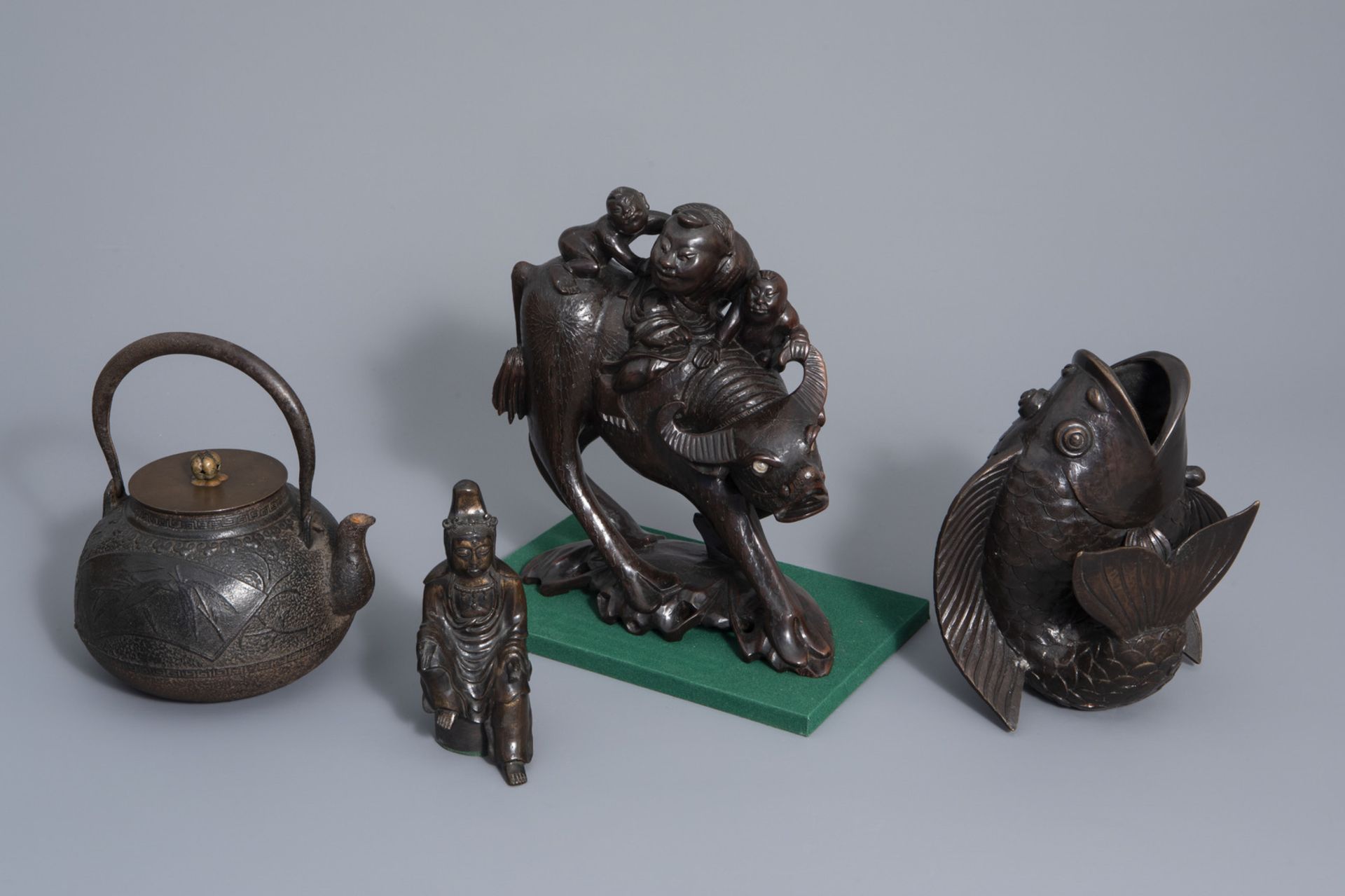 A Japanese bronze teapot, a carp wall vase, a Kannon figure and a carved wooden group, Meiji/Showa,