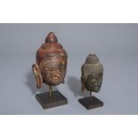 Two patinated bronze and gilt and polychrome painted stone Buddha heads, Burma/Thailand, 19th/20th C