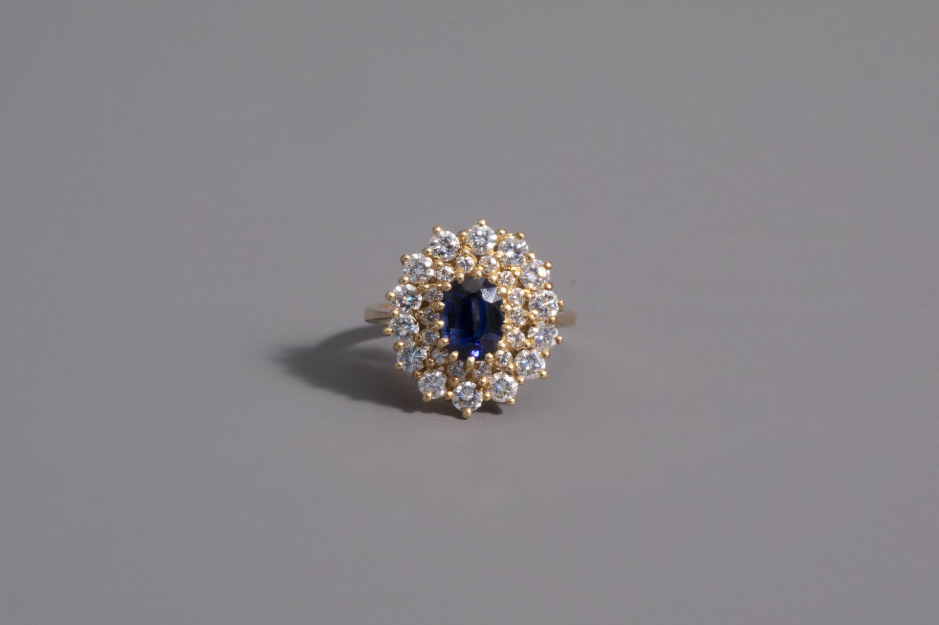 An 18 carat yellow gold ring set with a blue sapphire and 28 diamonds, 20th C. - Image 2 of 3