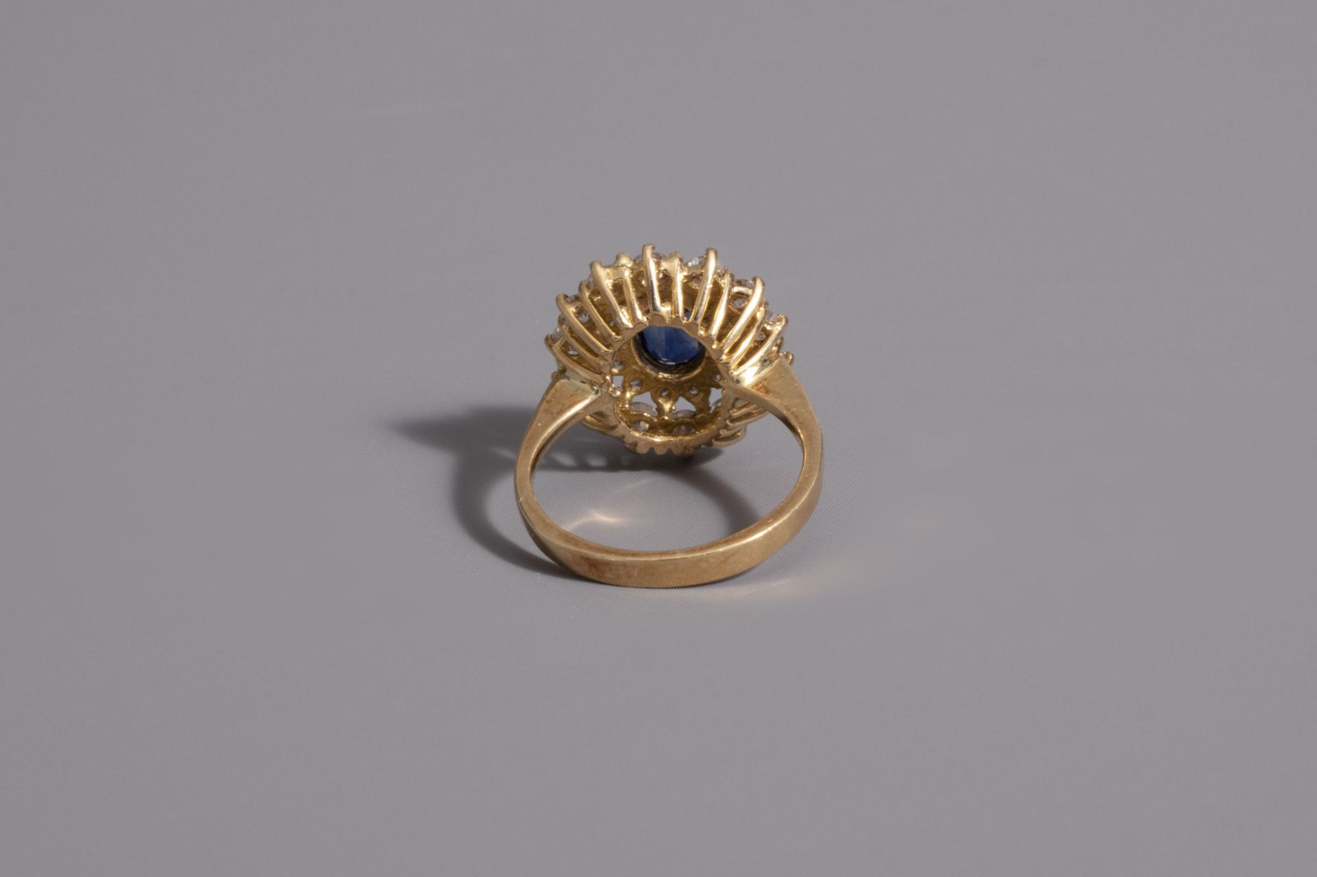 An 18 carat yellow gold ring set with a blue sapphire and 28 diamonds, 20th C. - Image 3 of 3