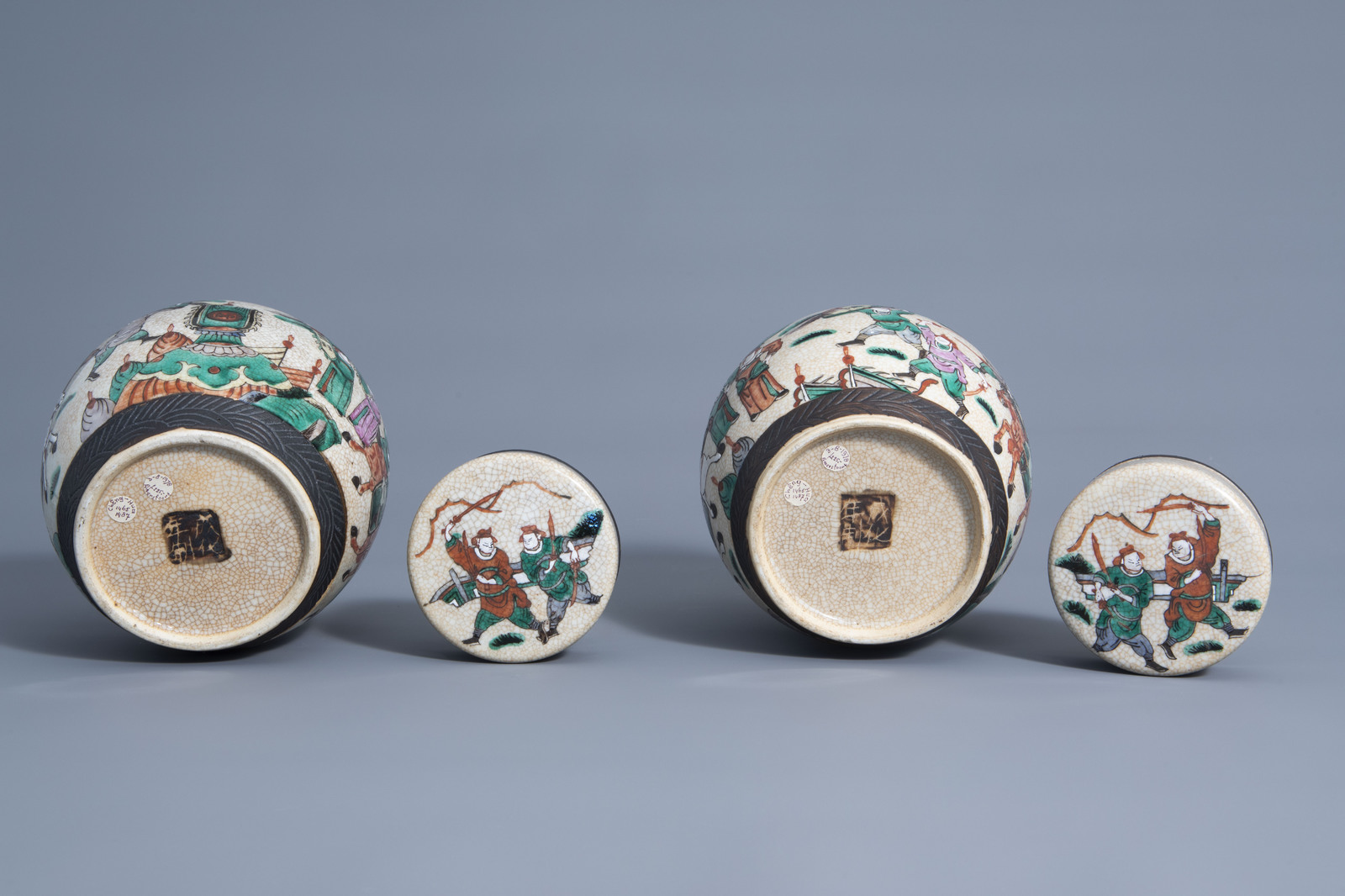 A pair of Chinese Nanking crackle glazed famille rose jars and covers with warrior scenes, 19th C. - Image 7 of 7