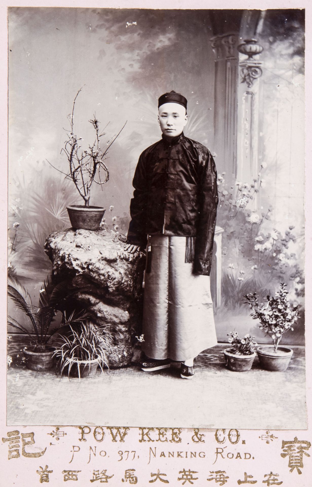 A Chinese black and white photographic portrait of a dignitary in a carved frame, dated 1901