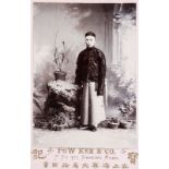 A Chinese black and white photographic portrait of a dignitary in a carved frame, dated 1901