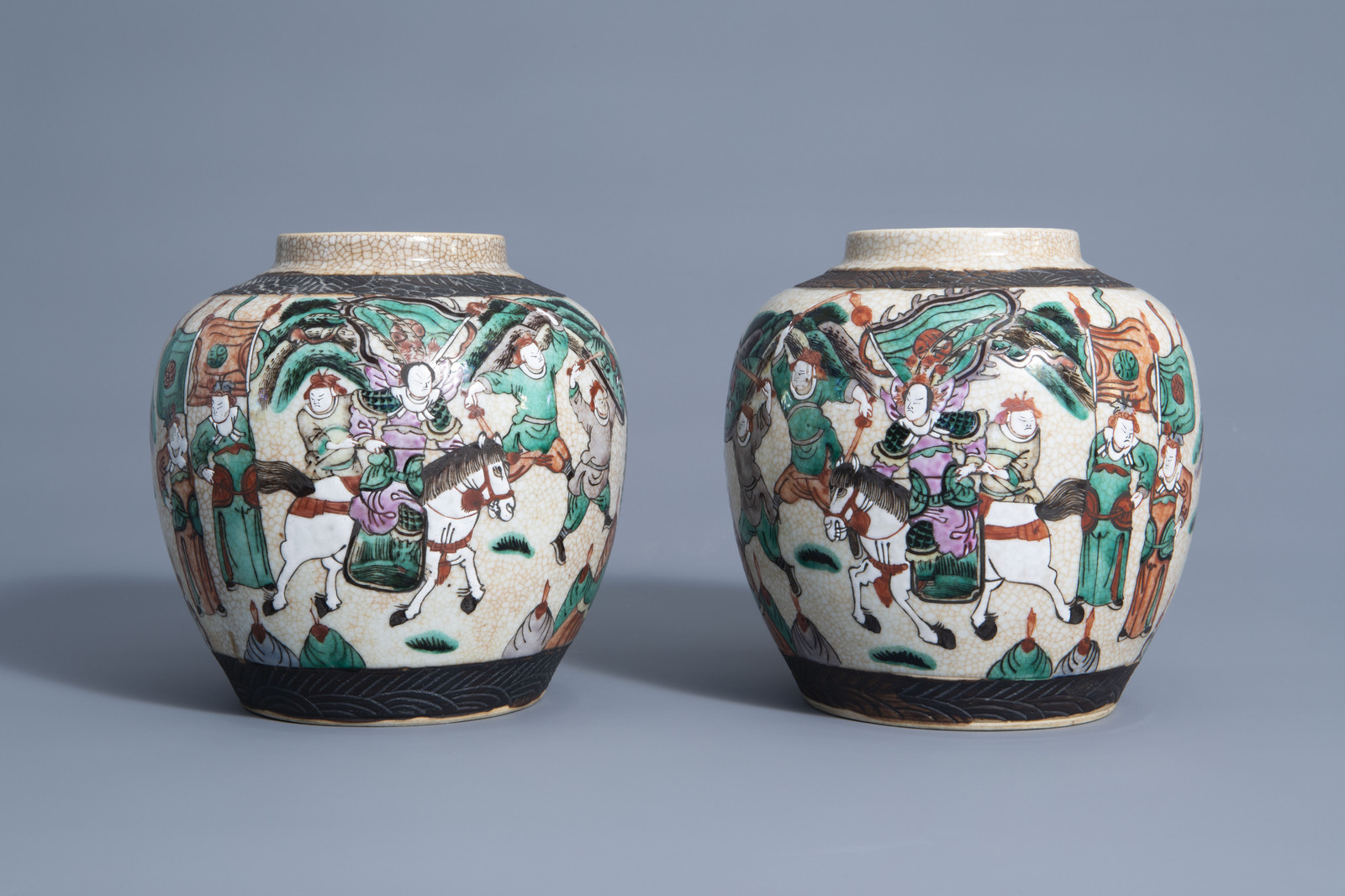 A pair of Chinese Nanking crackle glazed famille rose jars and covers with warrior scenes, 19th C. - Image 4 of 7