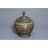 A Tibetan silver and semi-precious stones inlaid brass jar and cover, 20th C.