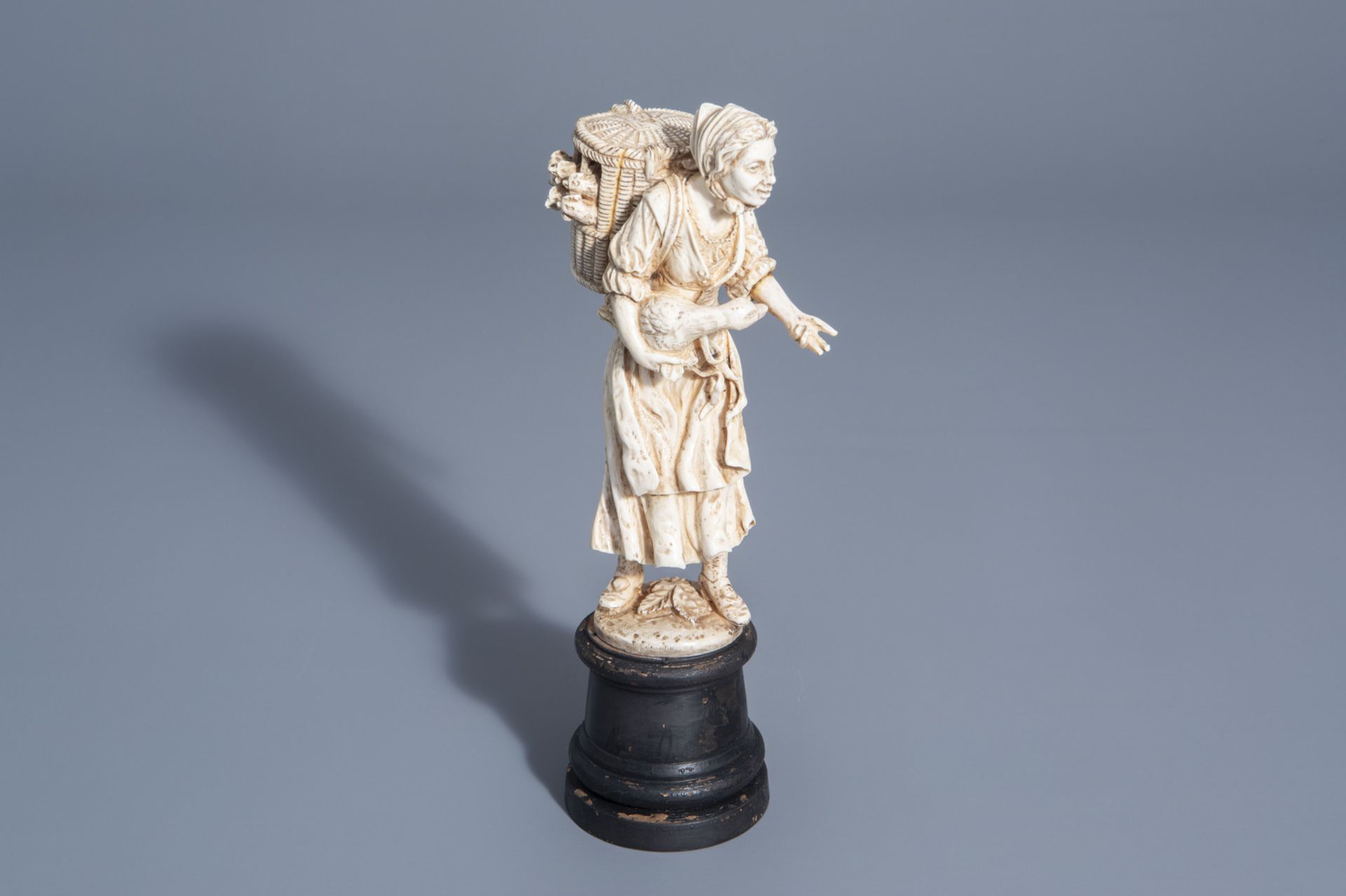 A carved ivory figure of a lady with poultry on wooden base, probably Dieppe, France, 19th C.