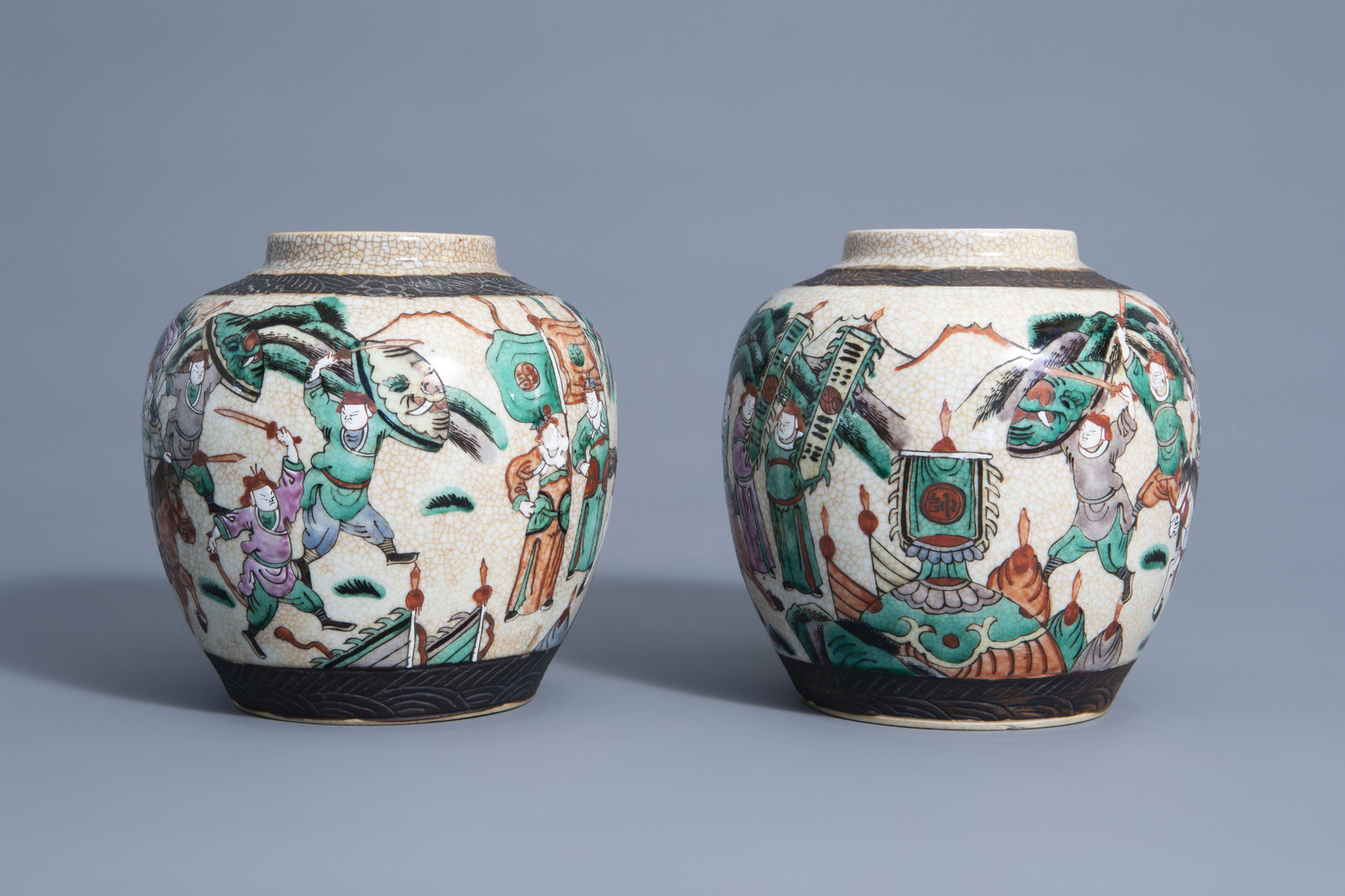 A pair of Chinese Nanking crackle glazed famille rose jars and covers with warrior scenes, 19th C. - Image 5 of 7