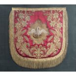 A framed fragment of a chasuble in silk and silver and gold thread with a pelican feeding the young,