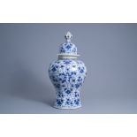 A large Dutch Delft blue and white vase and cover with cherubim on a floral ground, 18th C.