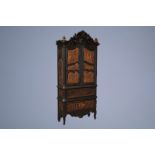 A colonial inspired and orientalist carved and ebonised wooden cabinet, first half of the 20th C.