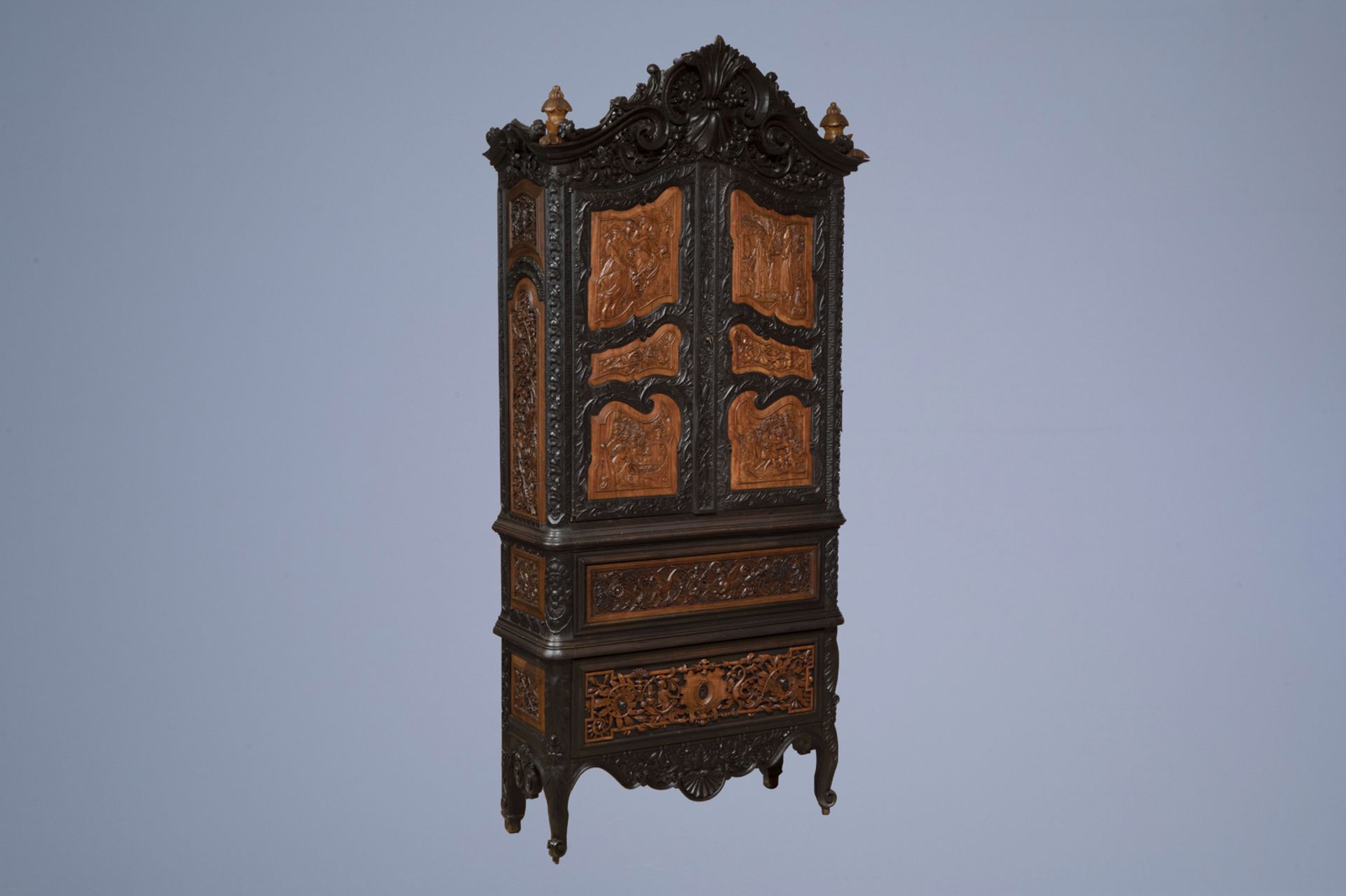 A colonial inspired and orientalist carved and ebonised wooden cabinet, first half of the 20th C.