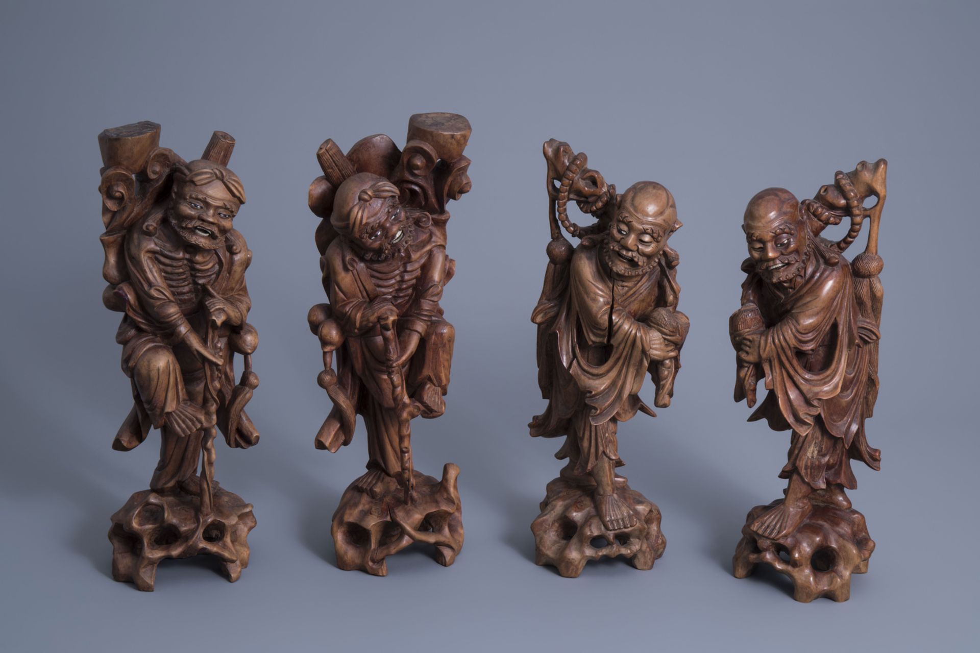 Four Chinese carved wooden figures of immortals, 19th/20th C.