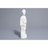 A tall Chinese Dehua blanc de Chine figure of Guanyin with a child, Kangxi