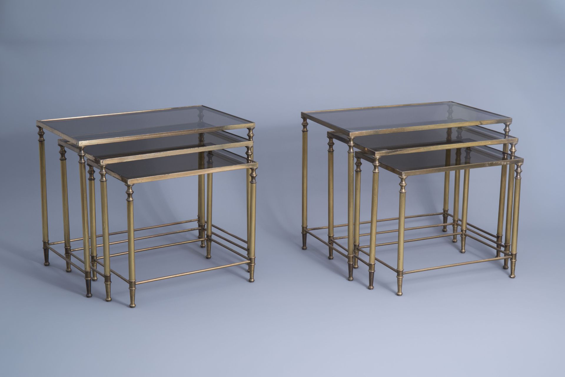 Two sets of three Maison Jansen rectangular gigogne side tables with a glass top, France, 1970's
