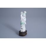 A Chinese carved jadeite figure of a lady on a wooden stand, 19th/20th C.