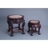 Two Chinese carved wooden stands with marble top, 19th/20th C.