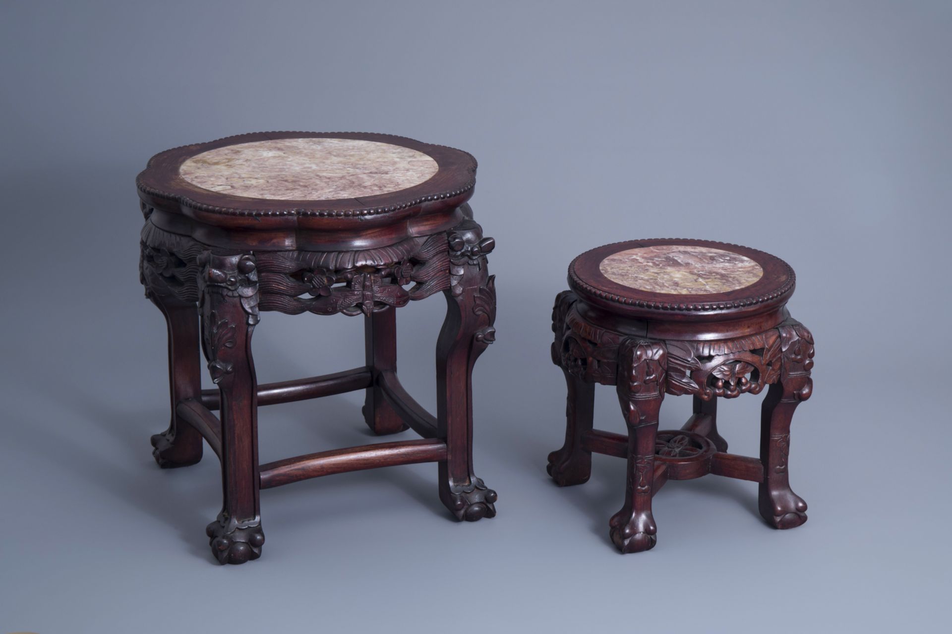 Two Chinese carved wooden stands with marble top, 19th/20th C.