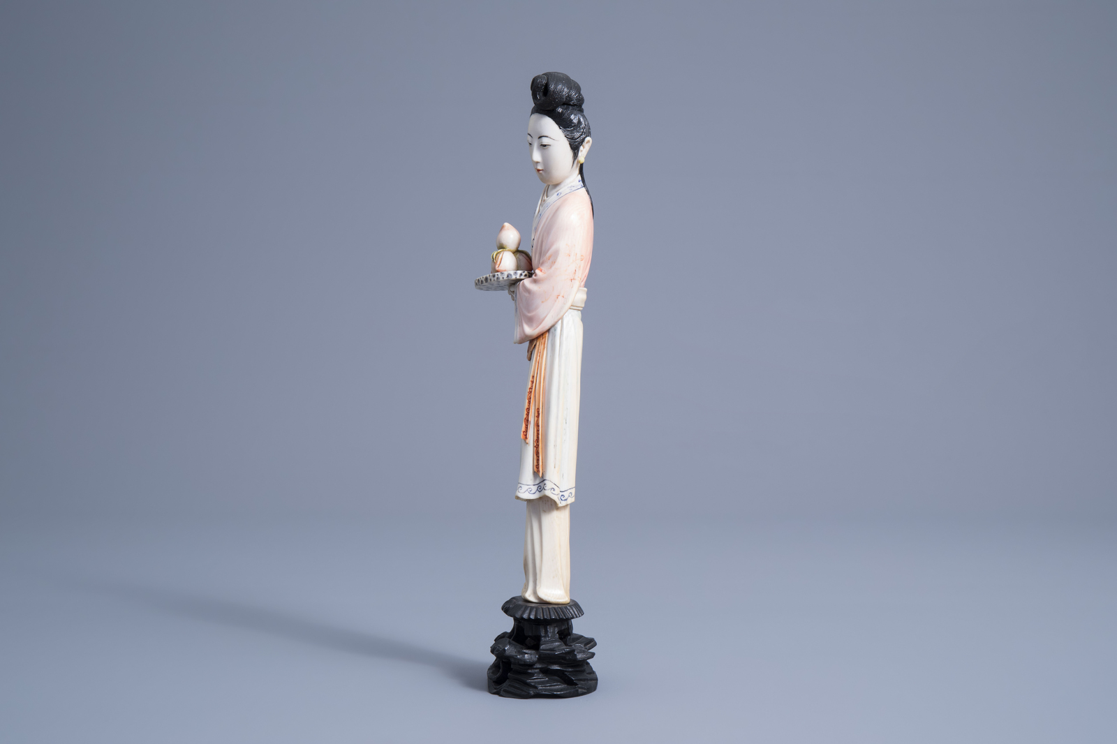 A Chinese polychrome ivory figure of a lady holding a tray of peaches, first half 20th C. - Image 5 of 7