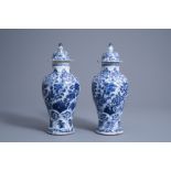 A pair of Chinese blue and white vases and covers with floral design, Kangxi