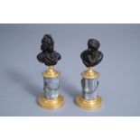 A pair of French patinated bronze busts of Voltaire and Rousseau on a gilt bronze mounted grey marbl