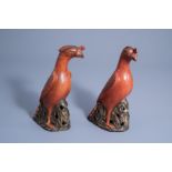 A pair of Chinese coral red and brown models of parrots, 20th C.