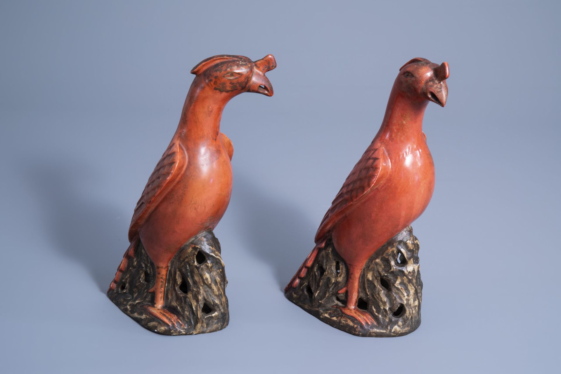 A pair of Chinese coral red and brown models of parrots, 20th C.