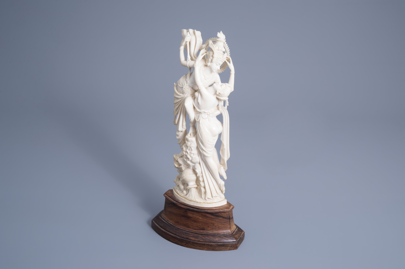 An Indian carved ivory group of a loving and embracing couple on a wooden base, ca. 1900
