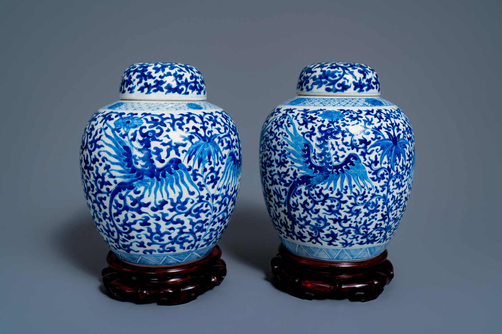 A pair of Chinese blue and white 'phoenix' jars and covers with floral design, Kangxi mark, 19th C.