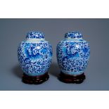 A pair of Chinese blue and white 'phoenix' jars and covers with floral design, Kangxi mark, 19th C.