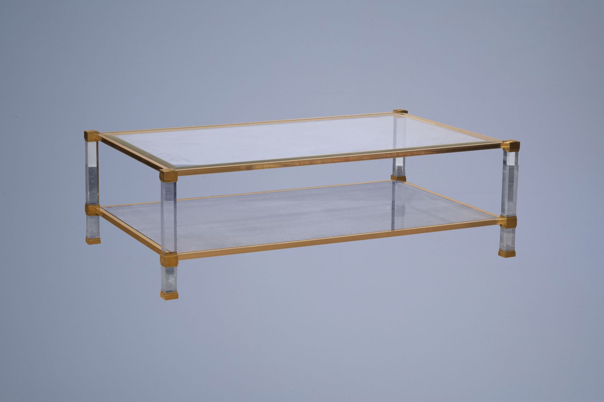 A Pierre Vandel brass and bevelled glass coffee table with lucite legs, France, 1970's