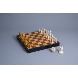 A Chinese chess set with ivory pieces and a reticulated puzzle ball on elephant stand, 1st half 20th