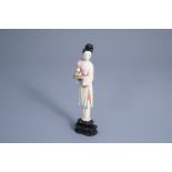 A Chinese polychrome ivory figure of a lady holding a tray of peaches, first half 20th C.