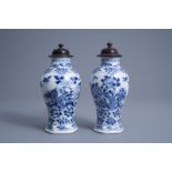 A pair of Chinese blue and white vases with wooden covers, Kangxi mark, 19th C.