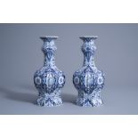 A pair of Dutch Delft blue and white garlic-head mouth vases with floral design, Makkum, 19th C.